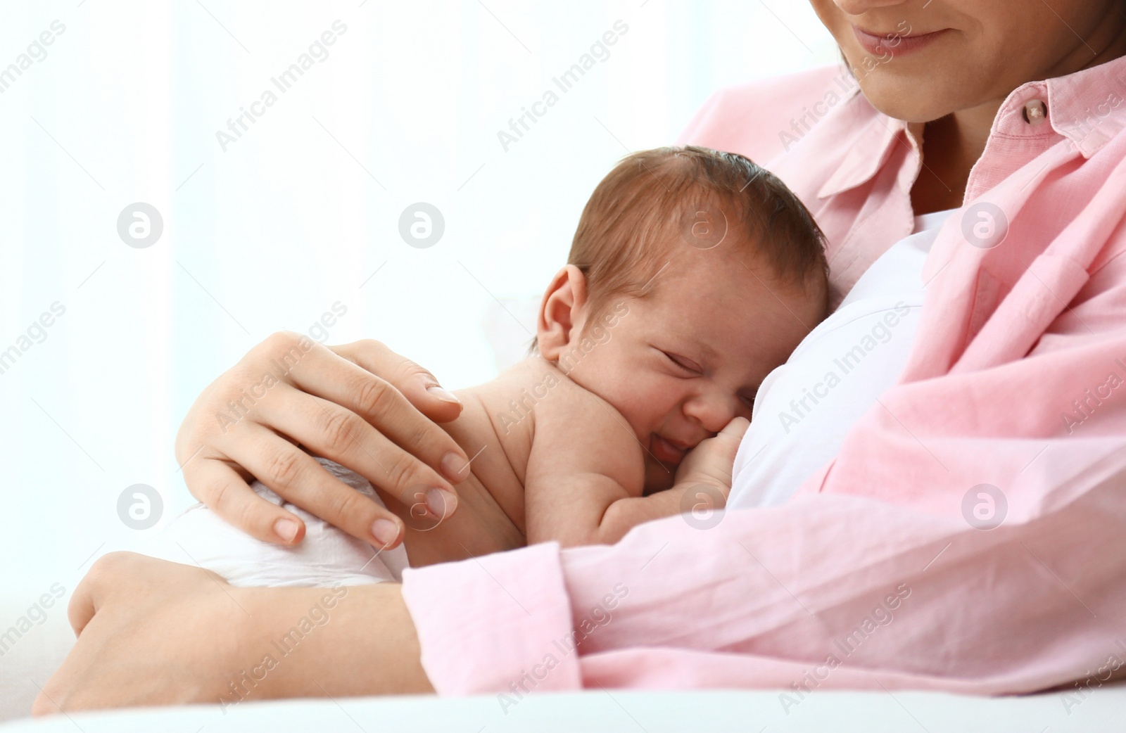 Photo of Young mother with her little baby sitting in armchair at home. Space for text