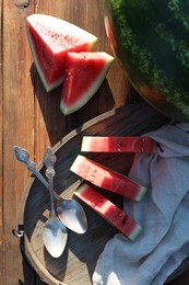 Photo of Tasty ripe watermelons and spoons on wooden table, flat lay