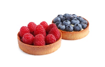 Tartlets with different fresh berries isolated on white. Delicious dessert