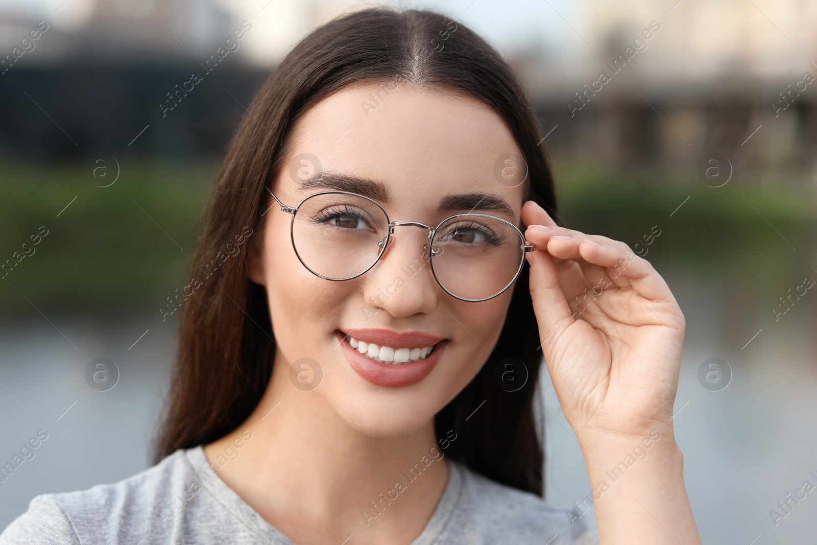 Photo of Portrait of beautiful woman in glasses outdoors. Attractive lady smiling and looking into camera