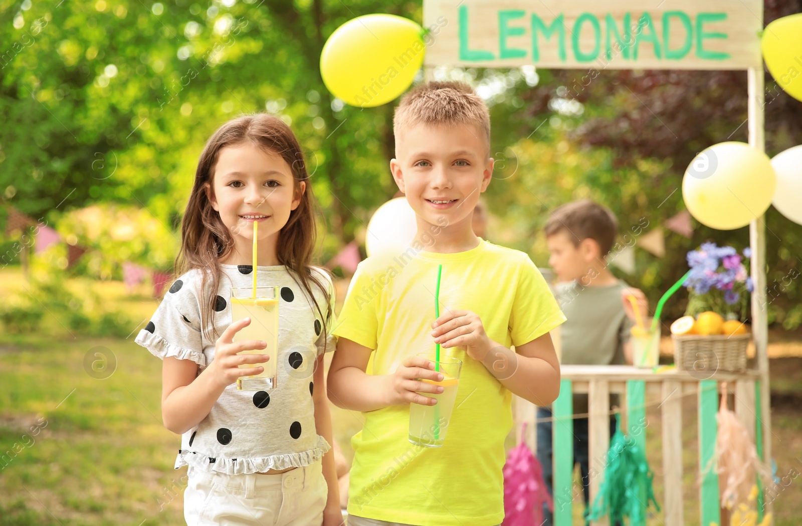 Photo of Little children with natural lemonade in park