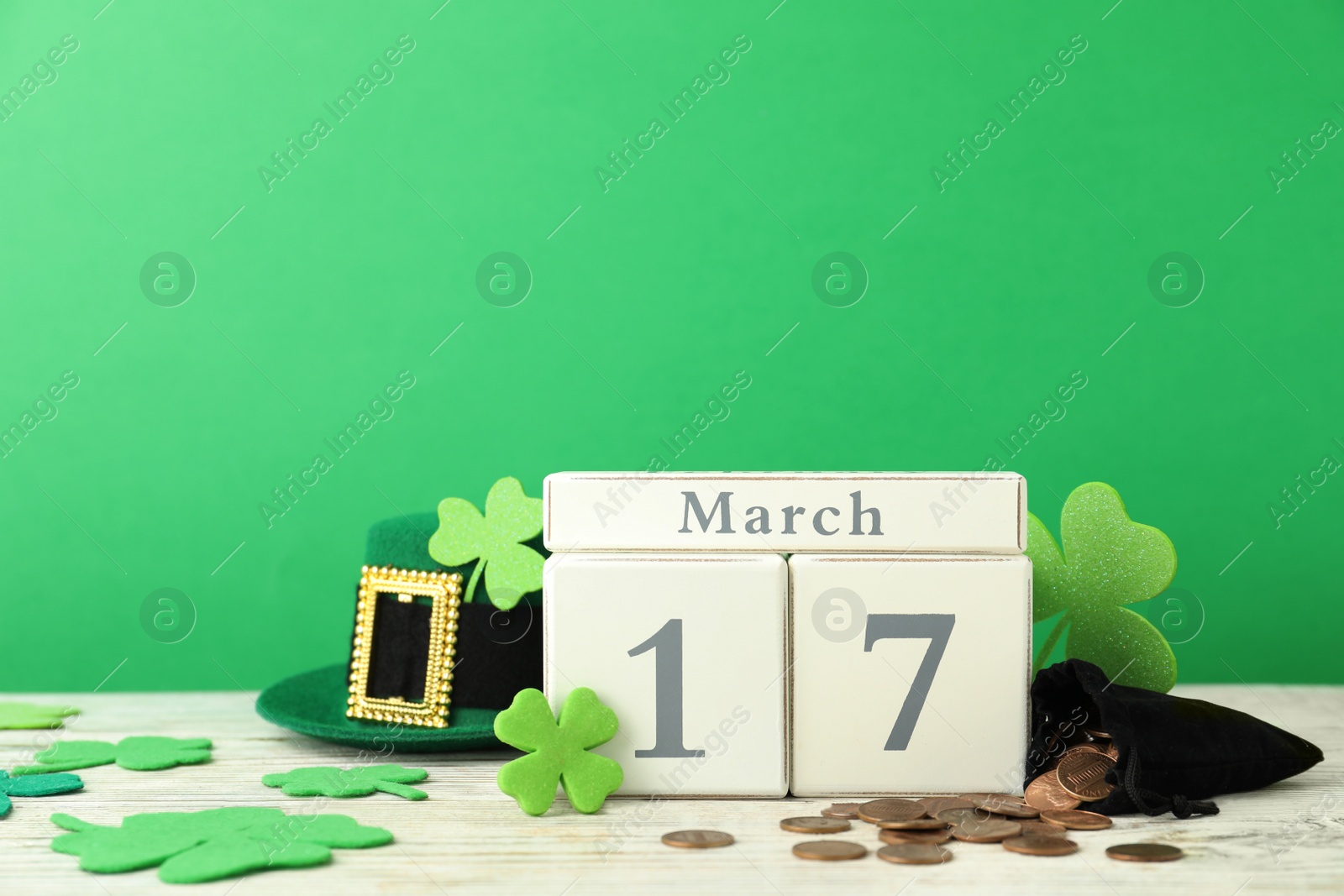 Photo of Composition with block calendar on white wooden table. St. Patrick's Day celebration