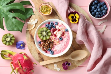 Photo of Flat lay composition with tasty smoothie bowl on pink wooden table