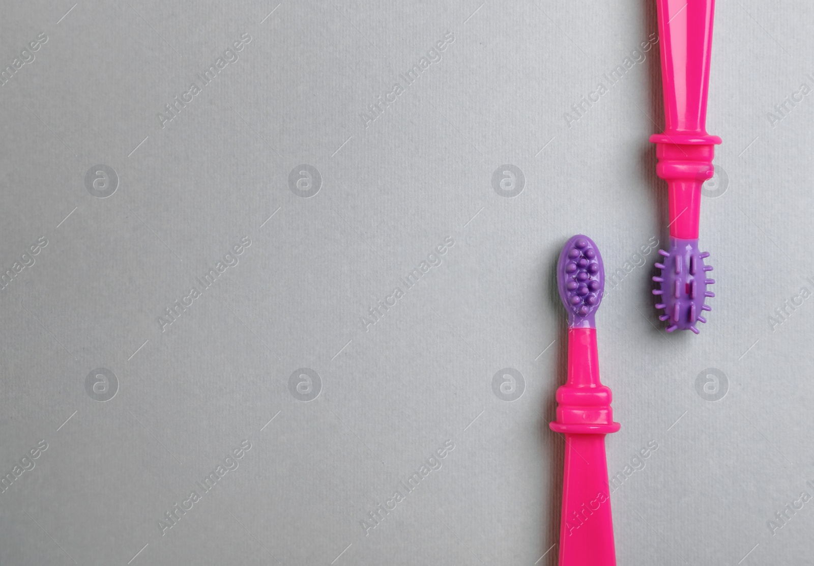 Photo of Manual toothbrushes for children on gray background, top view with space for text