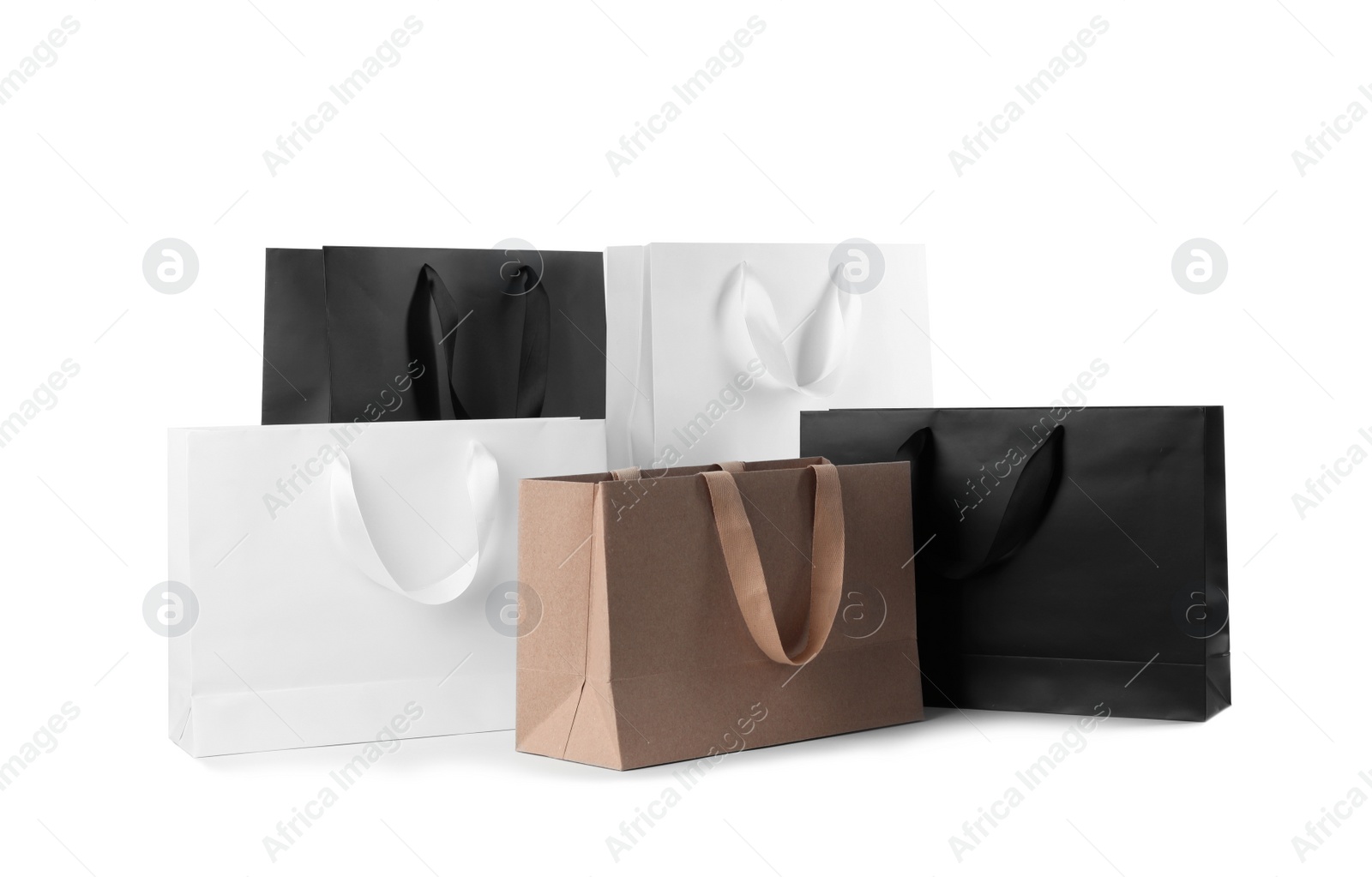 Photo of Paper shopping bags with comfortable handles on white background. Mockup for design