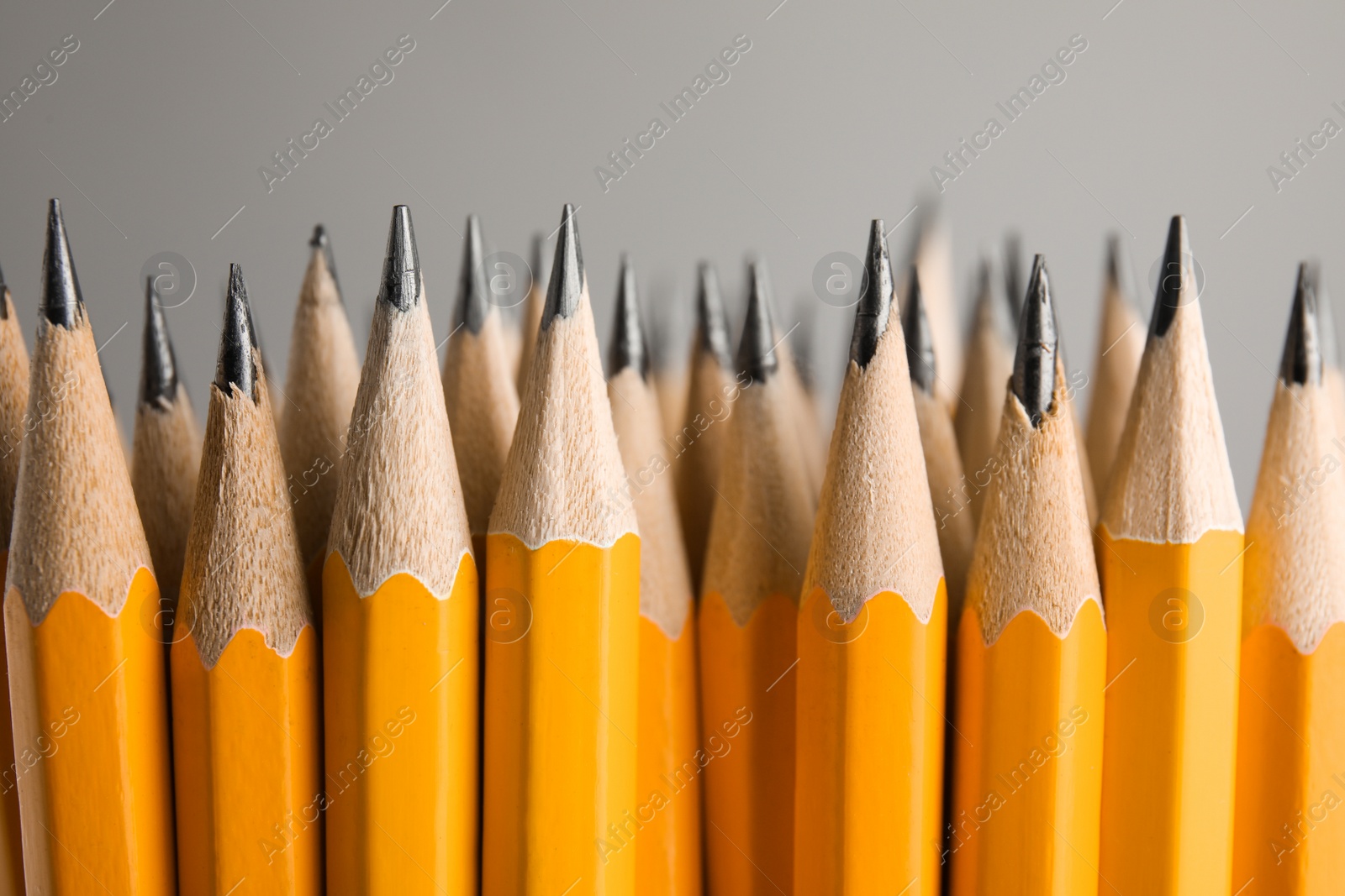 Photo of Many graphite pencils on grey background, closeup