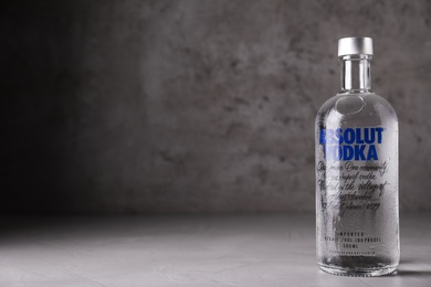 Photo of MYKOLAIV, UKRAINE - OCTOBER 04, 2019: Absolut vodka on table against grey background. Space for text
