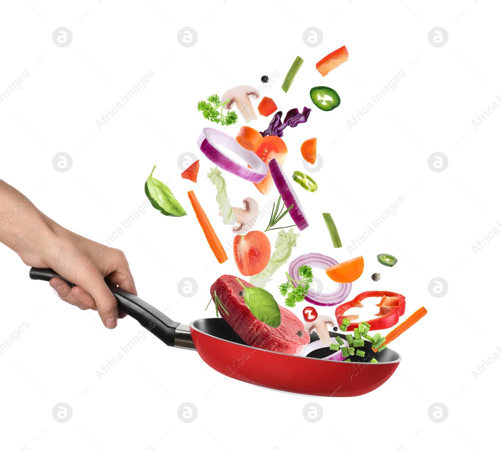 Image of Woman holding nonstick frying pan with falling beef slice and vegetables on white background. Process of cooking