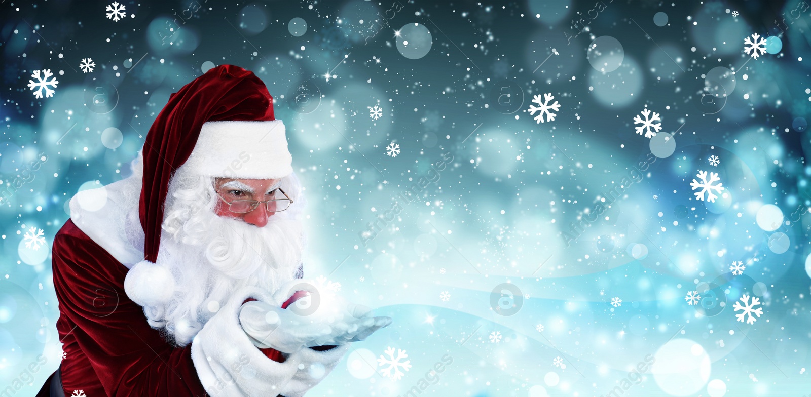 Image of Santa Claus blowing magic snow around, bokeh effect. Space for text