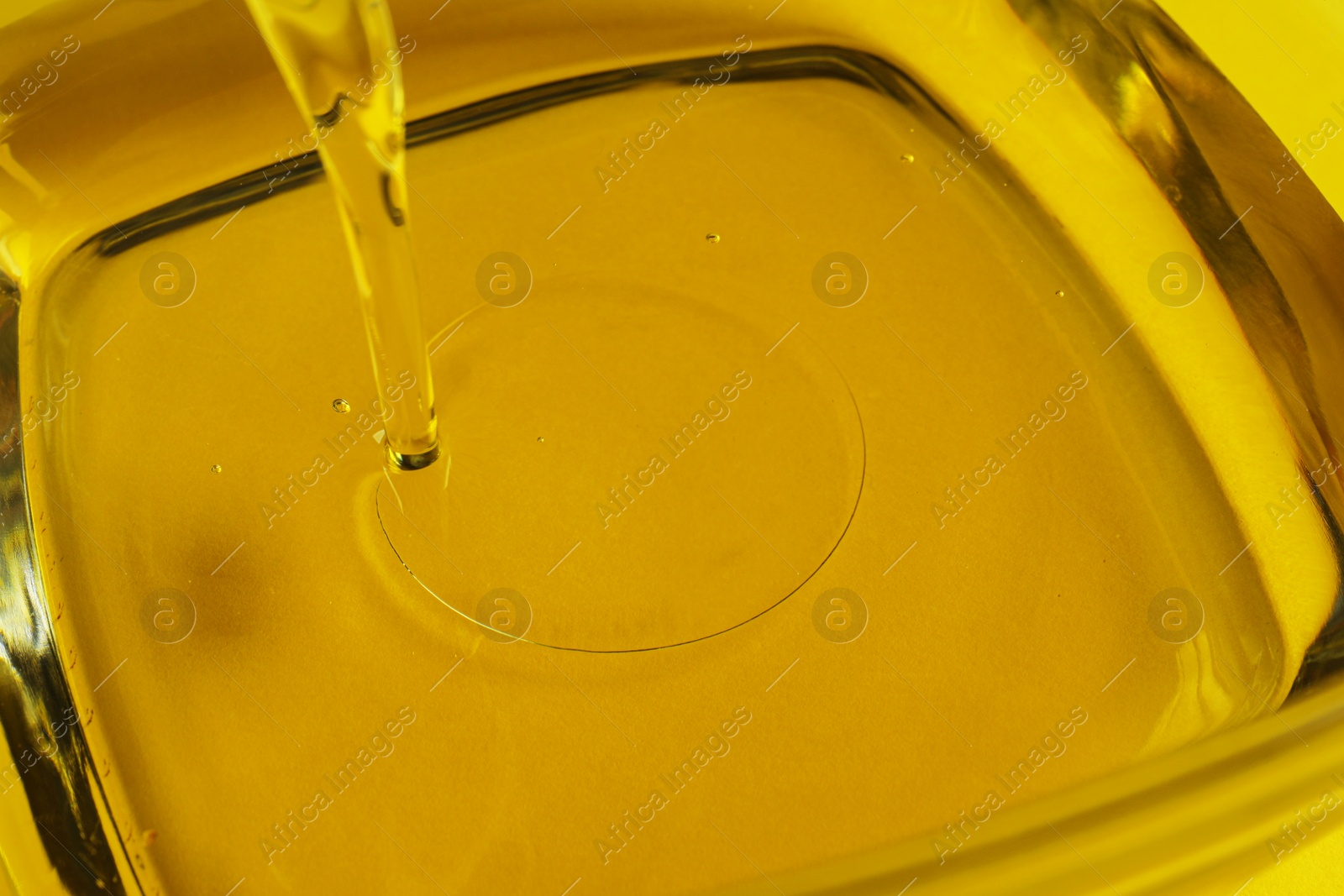 Photo of Pouring cooking oil into bowl, closeup view