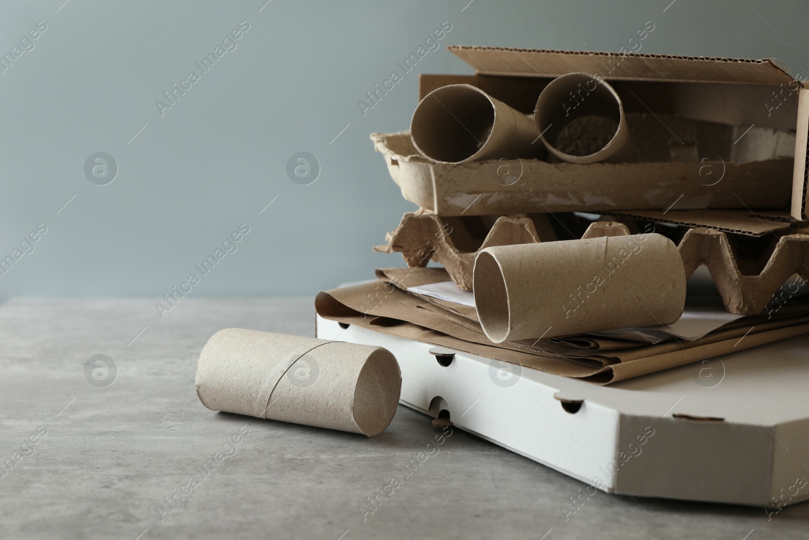 Photo of Stack of different waste paper on grey table, closeup. Space for text