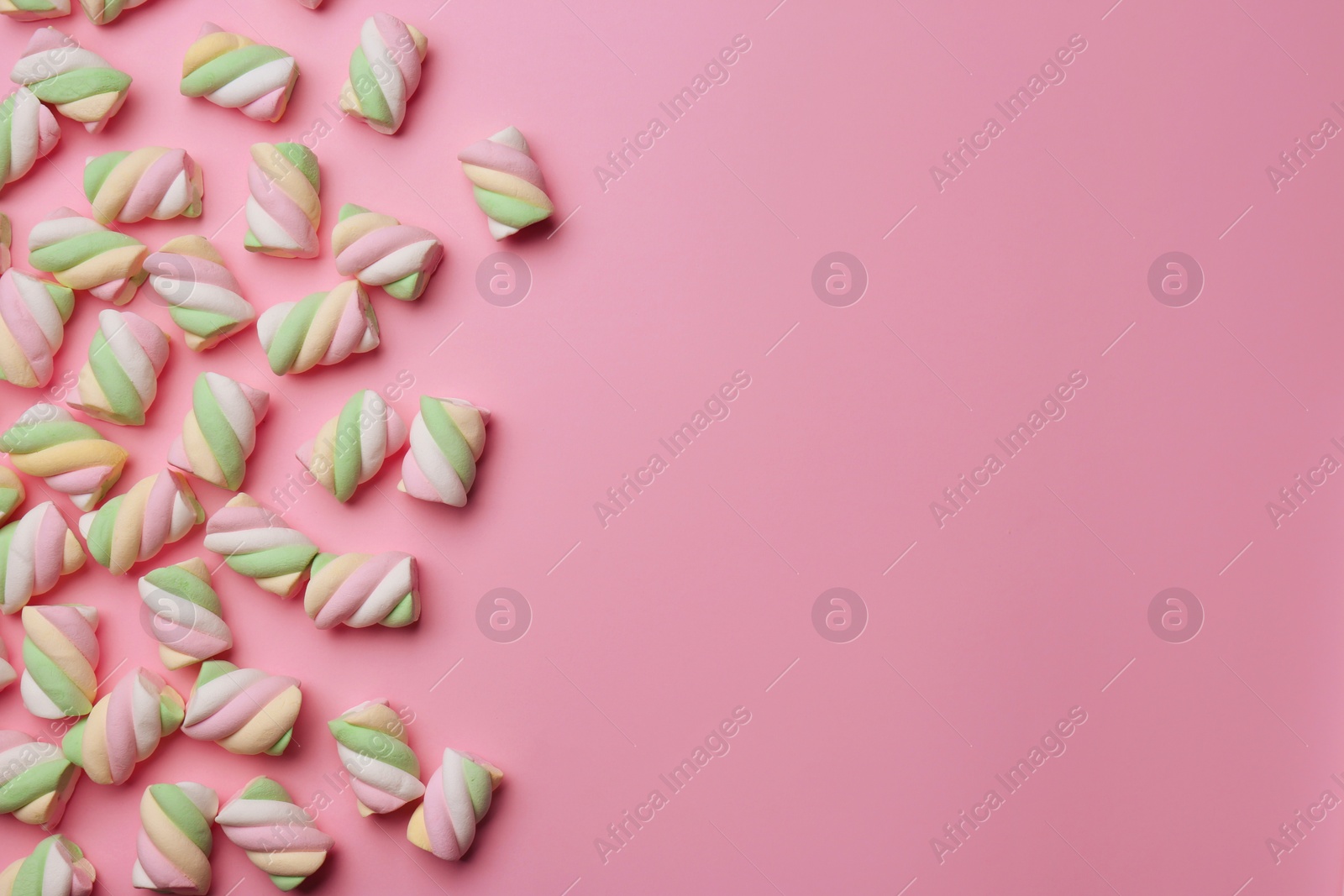 Photo of Delicious colorful marshmallows on pink background, flat lay. Space for text