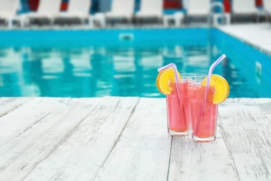 Photo of Refreshing cocktails near outdoor swimming pool on sunny day