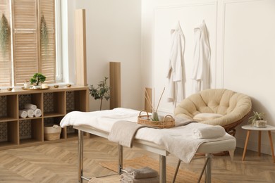 Stylish massage room interior with spa table in salon