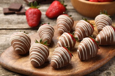 Delicious chocolate covered strawberries on wooden table, closeup