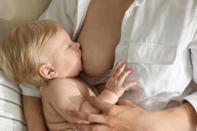 Photo of Mother breastfeeding her little baby at home. Healthy growth