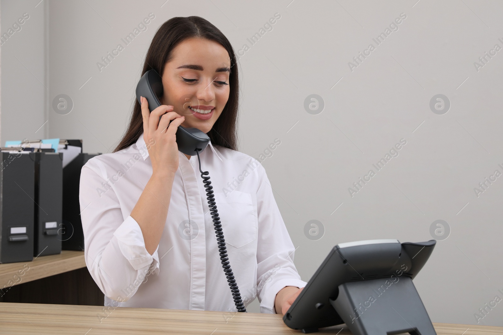 Photo of Female receptionist talking on phone at workplace