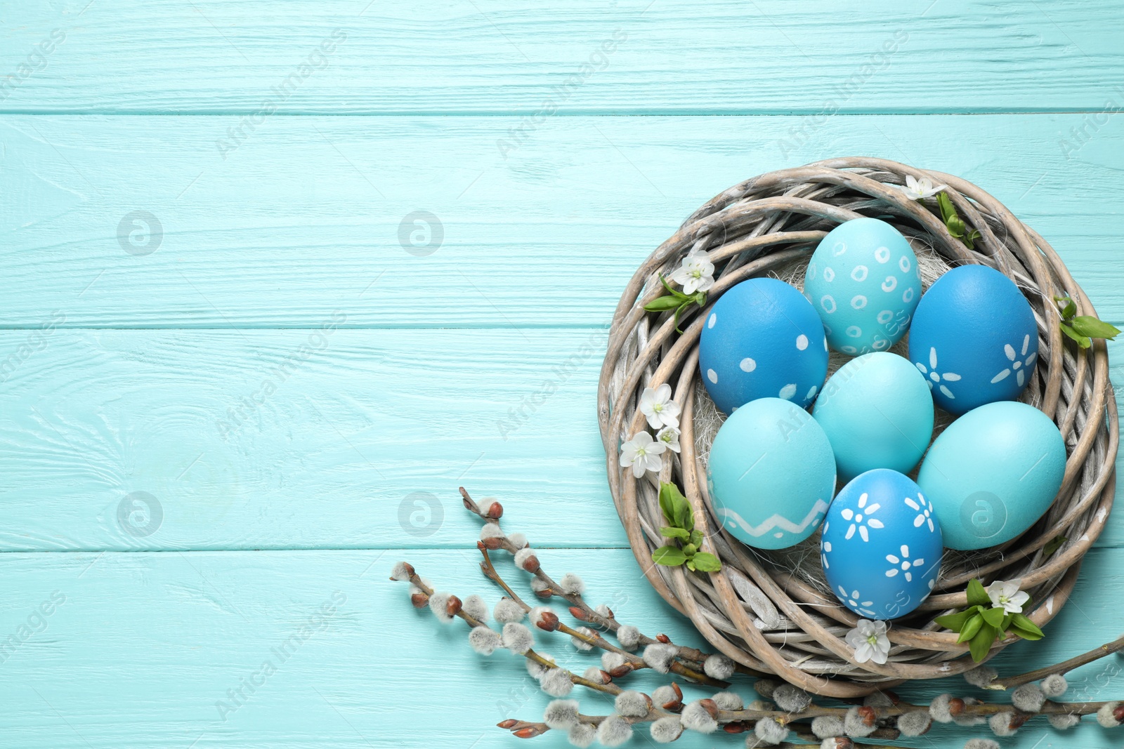 Photo of Flat lay composition with Easter eggs on light blue wooden background. Space for text