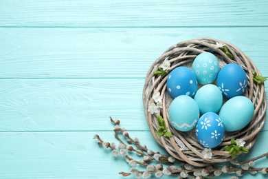 Flat lay composition with Easter eggs on light blue wooden background. Space for text