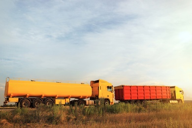 Photo of Modern bright trucks parked on country road