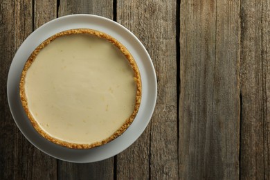 Tasty vegan tofu cheesecake on wooden table, top view. Space for text