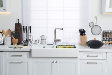 Photo of Countertop with sink and cooking utensils in kitchen