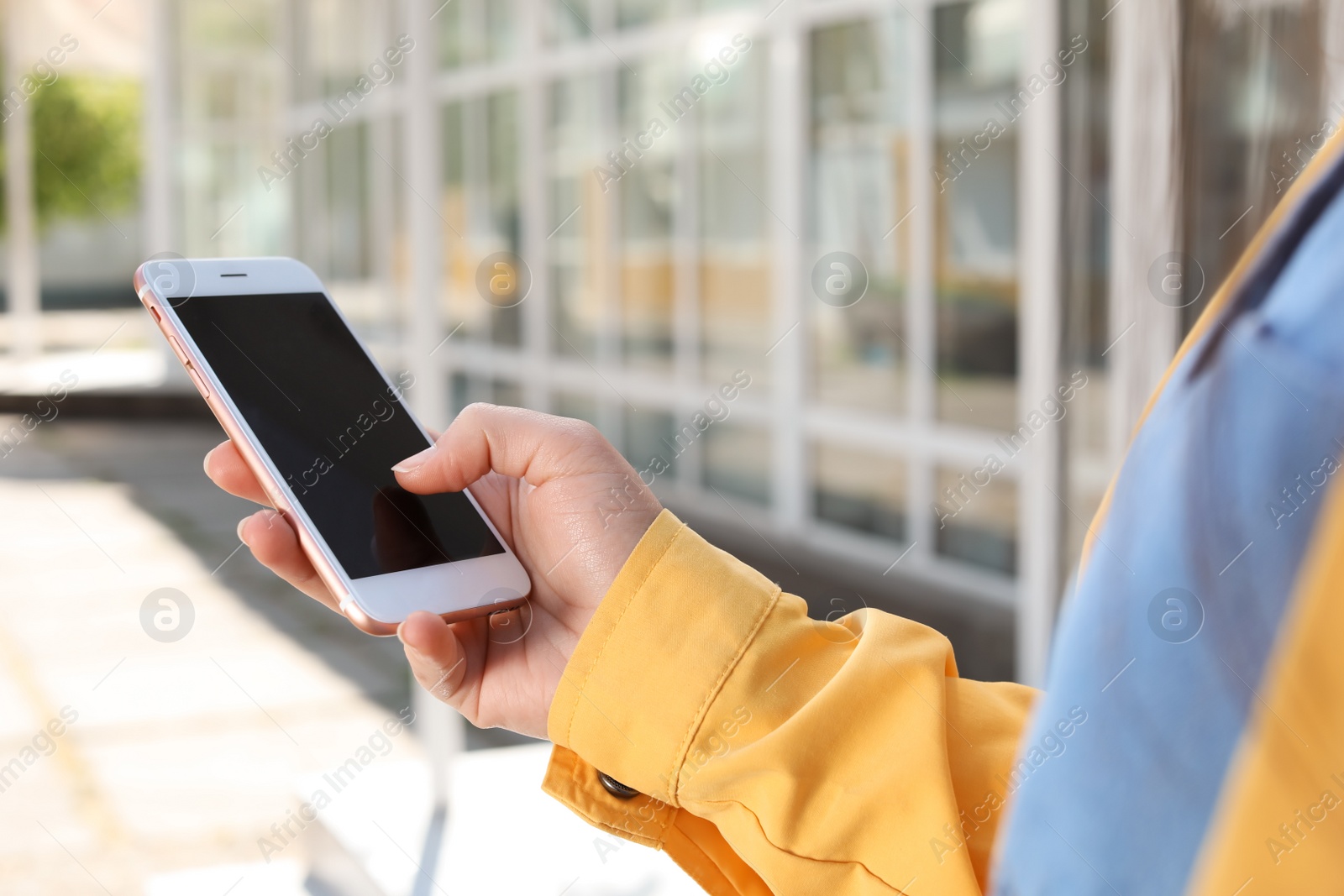 Photo of Young woman using phone outdoors on sunny day