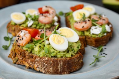 Photo of Delicious sandwiches with guacamole, shrimps and eggs on plate, closeup