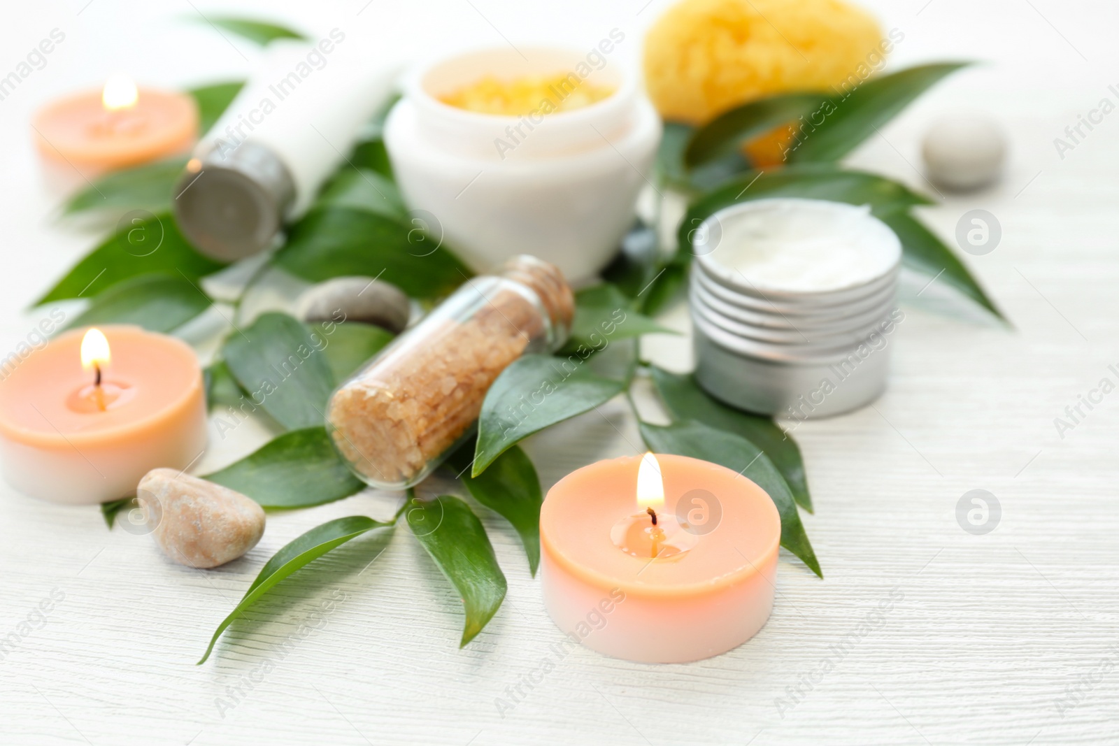 Photo of Beautiful composition with spa cosmetics and candles on light background