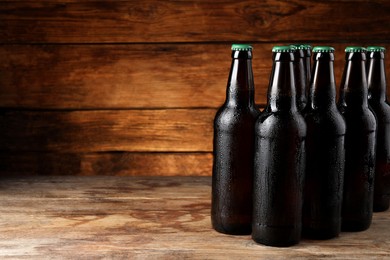 Many bottles of beer on wooden table, space for text