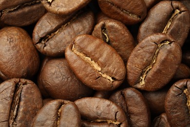 Photo of Pile of roasted coffee beans as background, closeup