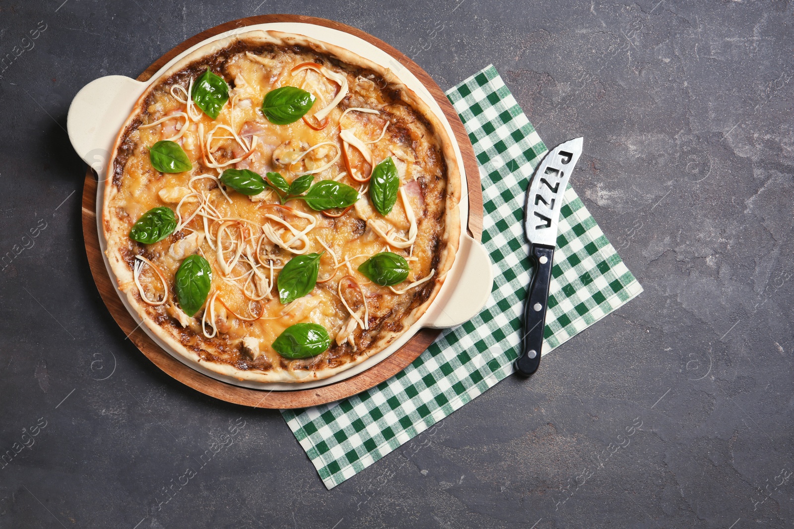 Photo of Board with delicious homemade pizza and knife on grunge background, top view