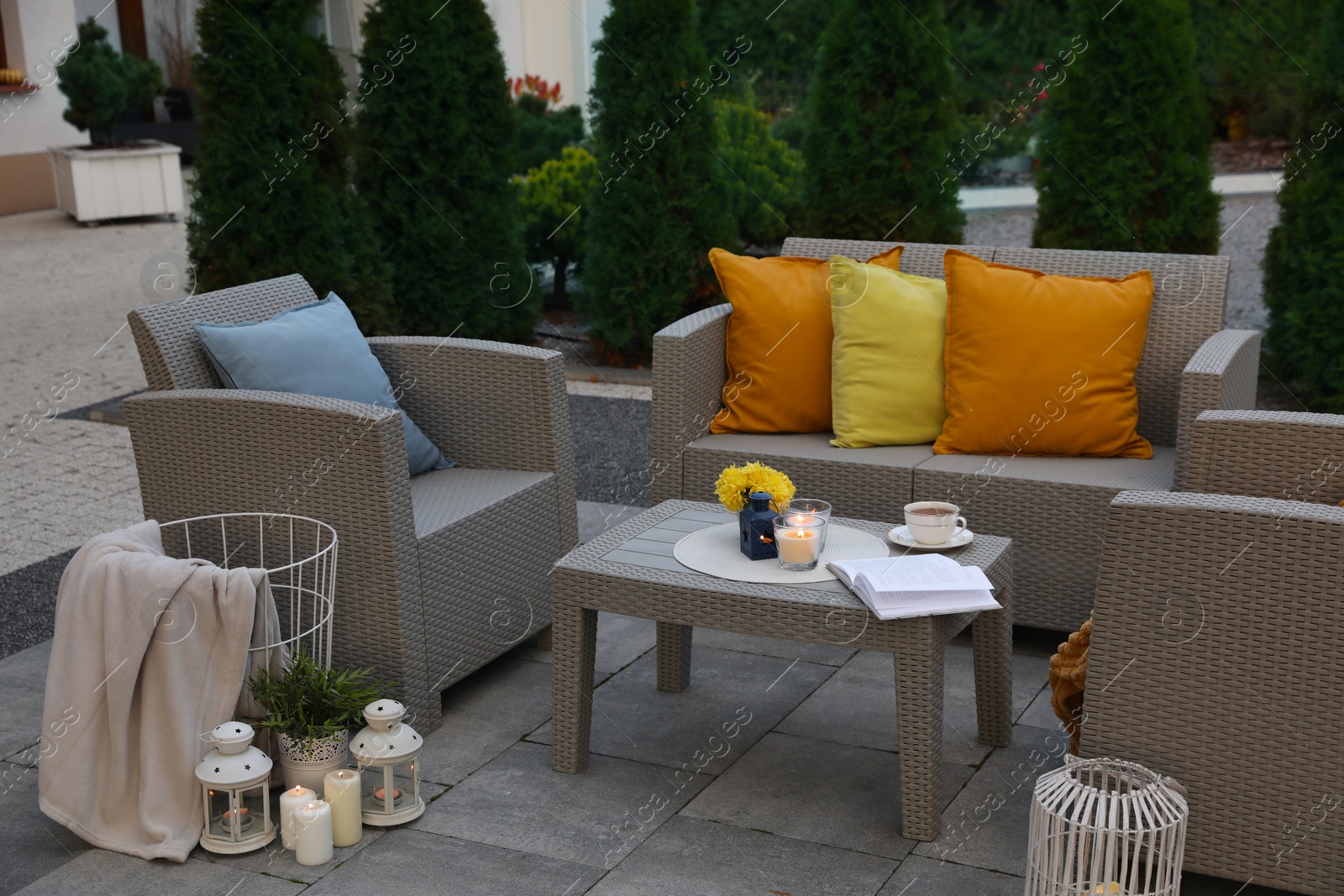 Photo of Beautiful rattan garden furniture, soft pillows and different decor elements in backyard