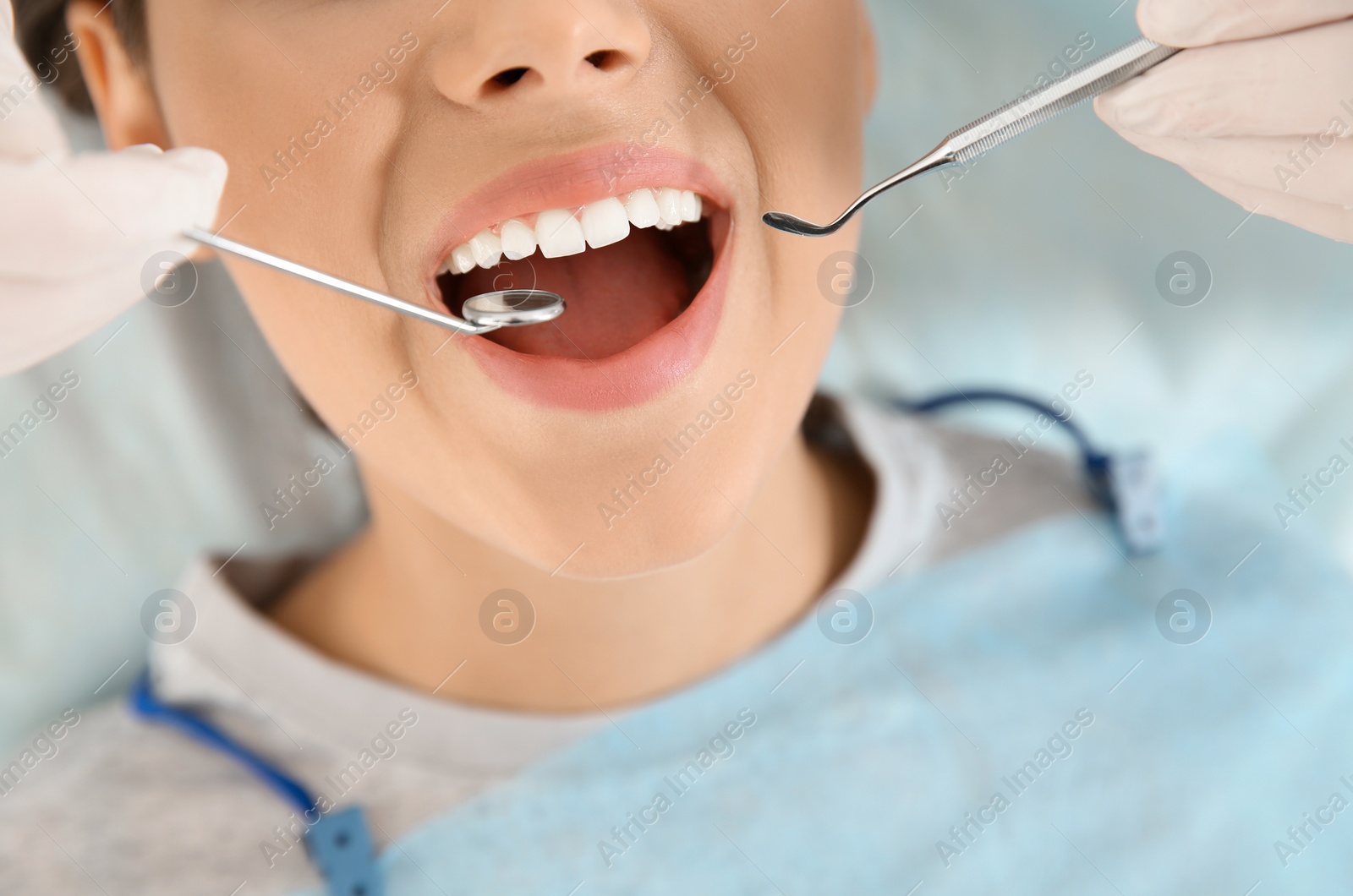 Photo of Dentist examining patient's teeth in modern clinic, closeup