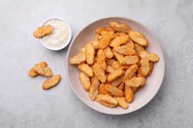 Photo of Crispy rusks and dip sauce on light table, flat lay