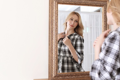 Young beautiful woman near mirror in makeup room