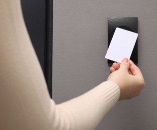 Woman opening magnetic door lock with key card, closeup. Home security