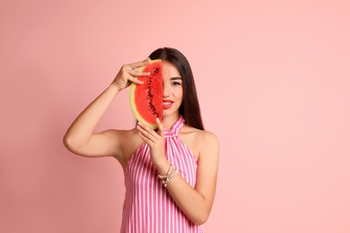 Photo of Beautiful young woman posing with watermelon on color background