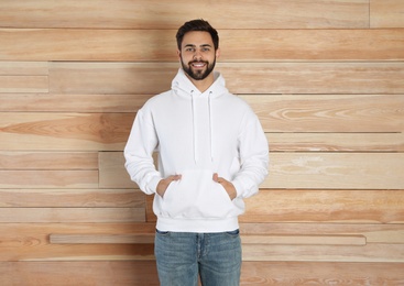 Portrait of young man in sweater at wooden wall. Mock up for design