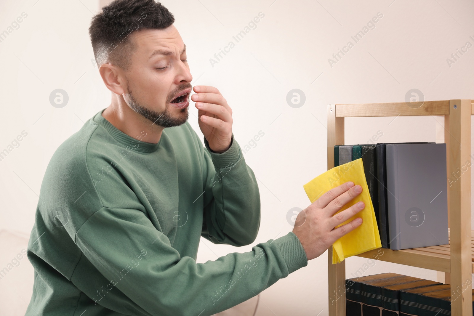 Photo of Man with dust allergy cleaning his home