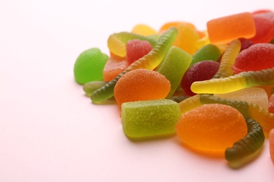 Pile of colorful jelly candies on pink background