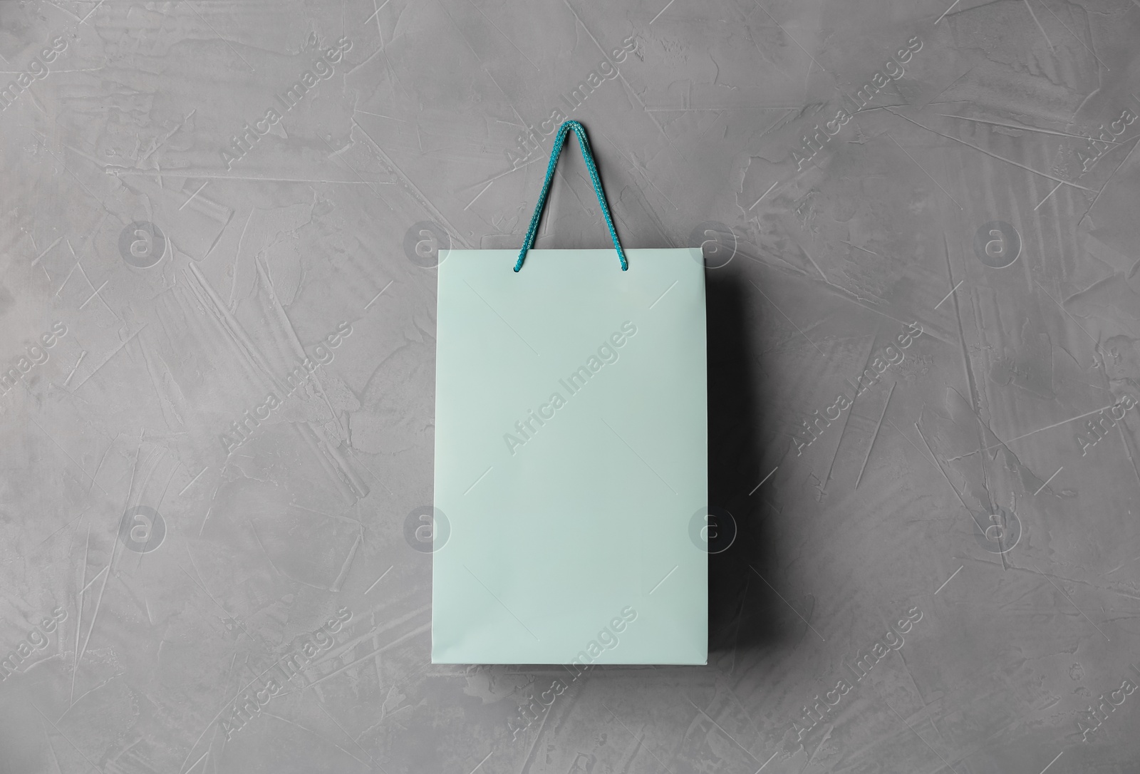 Photo of Paper shopping bag hanging on grey wall