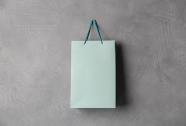 Paper shopping bag hanging on grey wall