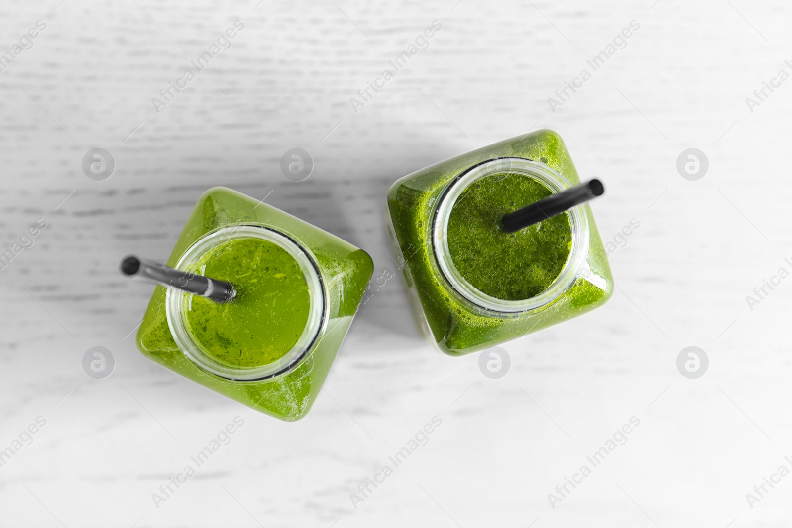 Photo of Bottles with delicious detox juice on light background, top view