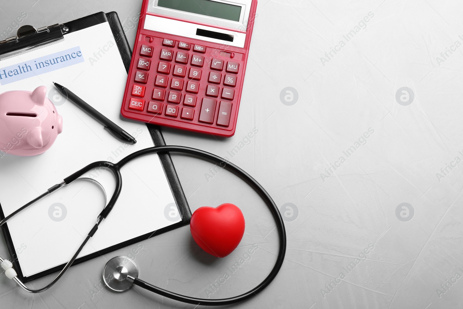 Photo of Medical insurance form, stethoscope, calculator and piggybank on grey background, flat lay. Space for text