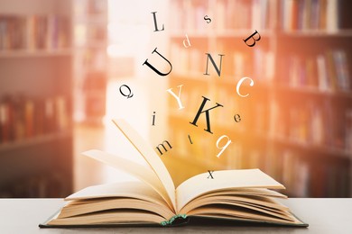 Open book with letters flying out of it in library