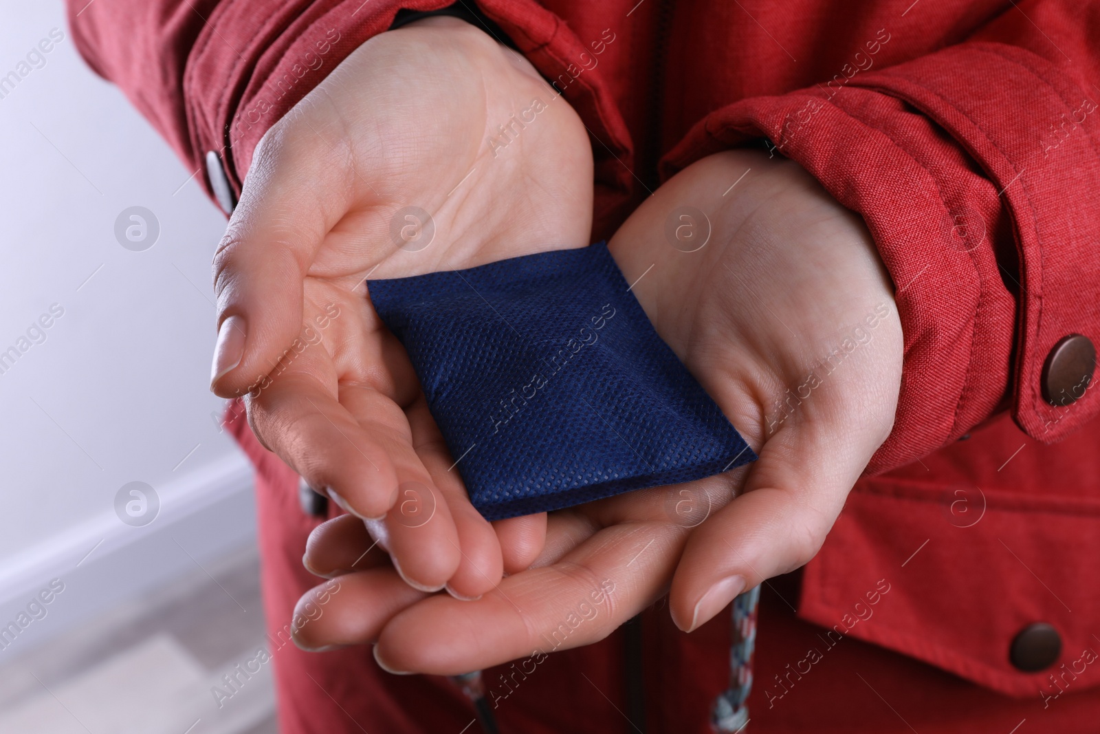 Photo of Woman holding hand warmer on white background, closeup