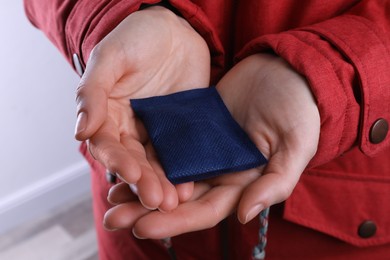 Woman holding hand warmer on white background, closeup