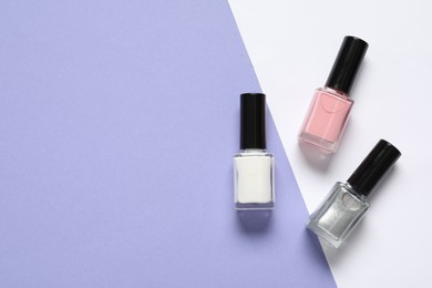 Photo of Nail polishes on color background, flat lay. Space for text