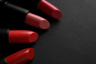 Photo of Beautiful lipsticks on black background, closeup. Space for text